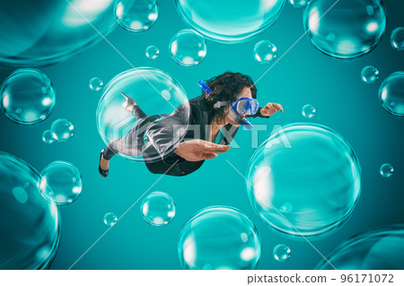 Woman swimming among air bubbles with mask and snorkel in a deep turquoise background 96171072