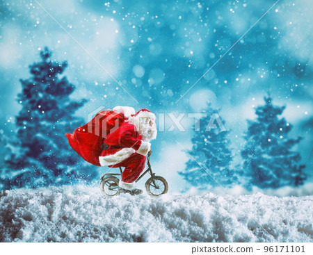 Santa Claus on a little bike on a winter landscape under the snow Santa Claus on a little bike on a winter landscape under the snow 96171101