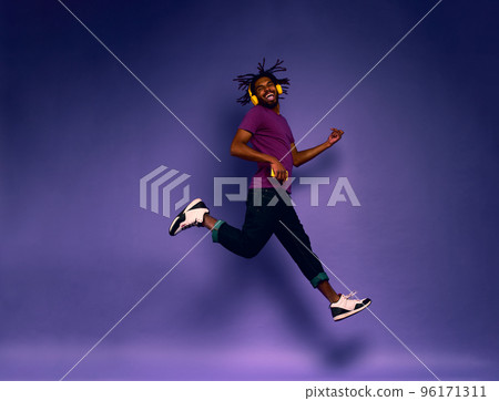 Boy with yellow headset listens to music and dances. emotional and energetic expression 96171311