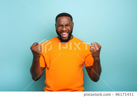 Boy wins something. Amazed and surprised expression face. Light blue background Boy wins something. Amazed and surprised expression face. Light blue background 96171431