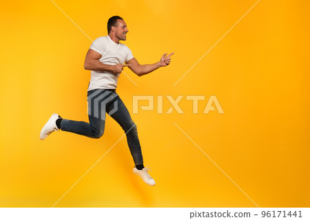 Sport man jumps on a yellow background. Happy and joyful expression. 96171441
