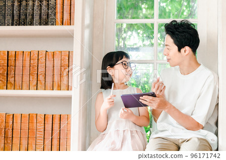 一位父親看著一個小學女生學習 96171742