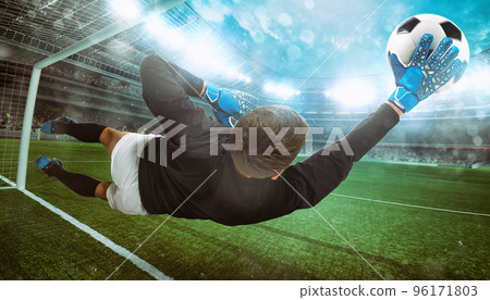 Goalkeeper catches the ball in the stadium during a football game 96171803