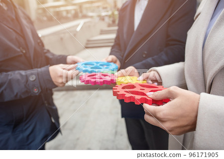 Business team connect pieces of gears. Teamwork, partnership and integration concept Business team connect pieces of gears. Teamwork, partnership and integration concept 96171905