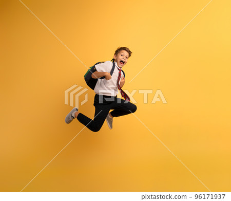 Young boy student runs fast to escape from school. Yellow background Young boy student runs fast to escape from school. Yellow background 96171937