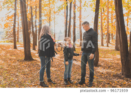 Family spend time in autumn park with a dog. Father, mother and daughter and jack russell terrier dog having fun in fall 96171939