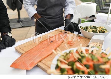 The cooks cut salmon fish at a wedding The cooks cut salmon fish at a wedding 96173268