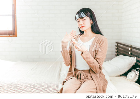 一個感冒的女人,她發高燒,用溫度計測量她的體溫 一個感冒的女人,她發高燒,用溫度計測量她的體溫 96175179