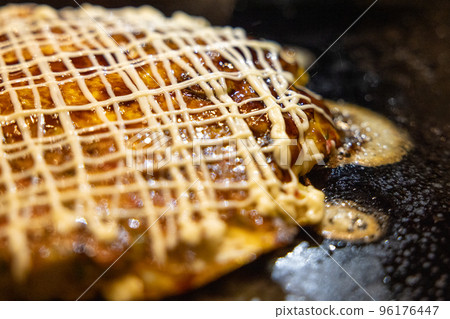 Okonomiyaki cooked on an iron plate Okonomiyaki cooked on an iron plate 96176447