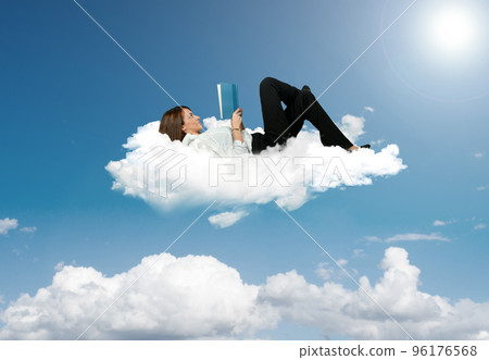 Businesswoman reading a book in a cloud 96176568