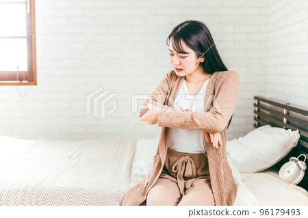 A Japanese woman who touches her elbow in bed and suffers from rheumatism and joint pain A Japanese woman who touches her elbow in bed and suffers from rheumatism and joint pain 96179493