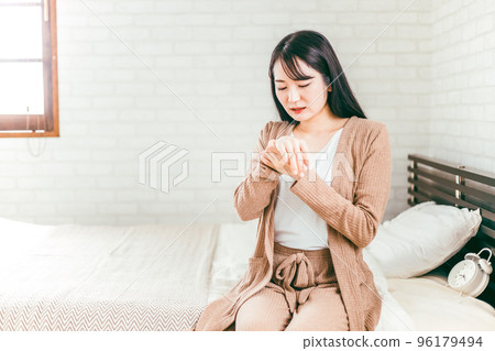 日本婦女在床上患有粗糙的手和濕疹 96179494