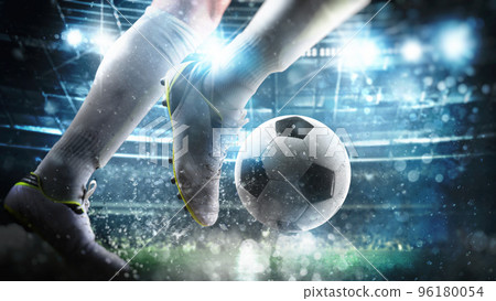 Football scene at night match with close up of a soccer player running to kick the ball at the stadium 96180054