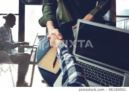 Handshaking business person in casual wear in the office. concept of teamwork and partnership. double exposure Handshaking business person in casual wear in the office. concept of teamwork and partnership. double exposure 96180061