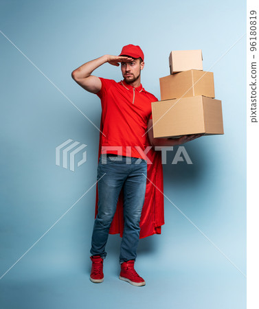 Courier acts like a powerful superhero. Concept of success and guarantee on shipment. Studio cyan background Courier acts like a powerful superhero. Concept of success and guarantee on shipment. Studio cyan background 96180819