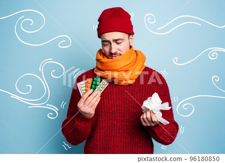 Boy caught a cold and uses pills to heal. Studio on Cyan background Boy caught a cold and uses pills to heal. Studio on Cyan background 96180850