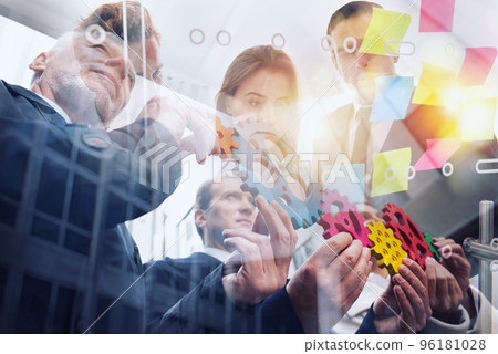 Business team connect pieces of gears. Teamwork, partnership and integration concept. Double exposure 96181028