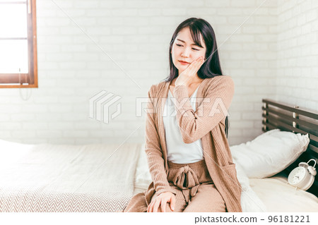 一名日本婦女坐在床上,患有蛀牙、牙周病和皰疹 一名日本婦女坐在床上,患有蛀牙、牙周病和皰疹 96181221