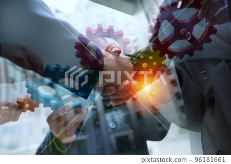 Business team connect pieces of gears. Handshake overlay. Teamwork, partnership and integration concept Business team connect pieces of gears. Handshake overlay. Teamwork, partnership and integration concept 96181661