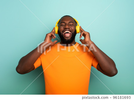 Boy with yellow headset listens to music and dances. emotional and energetic expression 96181693