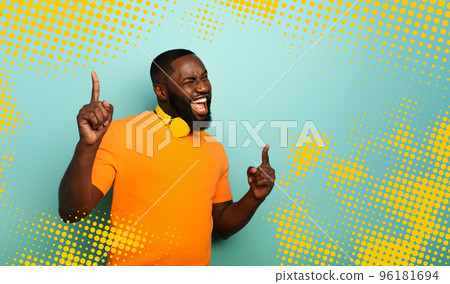 Boy with yellow headset listens to music and dances with energy on cyan background Boy with yellow headset listens to music and dances with energy on cyan background 96181694