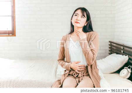 Japanese woman suffering from throat, tonsils and neck in bedroom 96181745