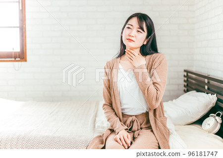 Japanese woman suffering from throat, tonsils and neck in bedroom 96181747