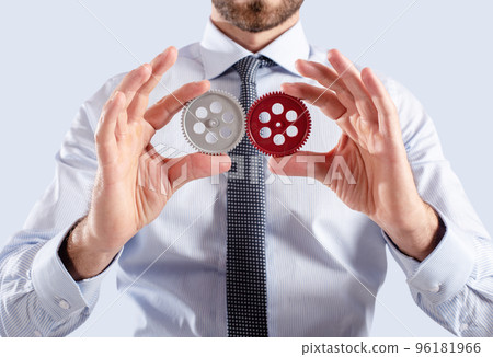 Businessman connects gears. Teamwork and partnership concept Businessman connects gears. Teamwork and partnership concept 96181966
