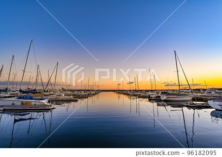 Yacht harbor with beautiful magic hour in the background Yacht harbor with beautiful magic hour in the background 96182095