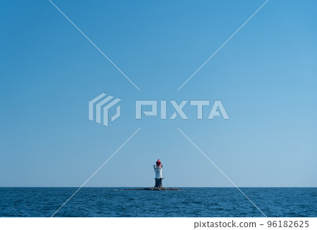 navigation buoy or small beacon on tiny island in the calm blue sea. 96182625
