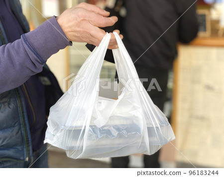 Male hand holding plastic bag for lunch 96183244