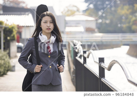 A high school girl wearing Stax carrying her guitar to school 96184848