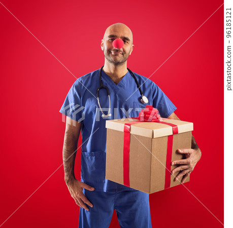 Nurse with clown nose and gift on red background 96185121