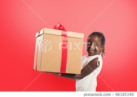 Happy little girl with a Christmas gift. 96185140