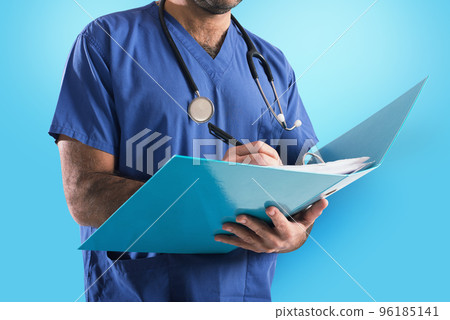 Doctor with stethoscope writes on medical record 96185141