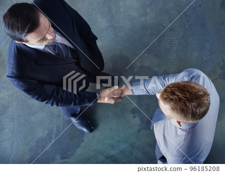 Handshaking business person in office. concept of teamwork and partnership Handshaking business person in office. concept of teamwork and partnership 96185208