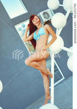a girl in a swimsuit poses with plastic balls 96185740