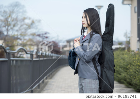 A high school girl wearing Stax carrying her guitar to school A high school girl wearing Stax carrying her guitar to school 96185741