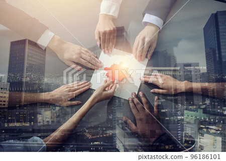 Business people join puzzle pieces in office. Concept of teamwork and partnership. double exposure with light effects 96186101