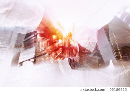 Handshaking business person in the office. concept of teamwork and partnership. double exposure Handshaking business person in the office. concept of teamwork and partnership. double exposure 96186213