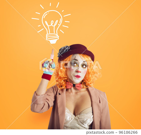 Pensive clown girl thinks an idea. Yellow background. Pensive clown girl thinks an idea. Yellow background. 96186266
