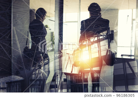 Silhouettes of businessman at the airport who waits for boarding. Double exposure. Silhouettes of businessman at the airport who waits for boarding. Double exposure. 96186305