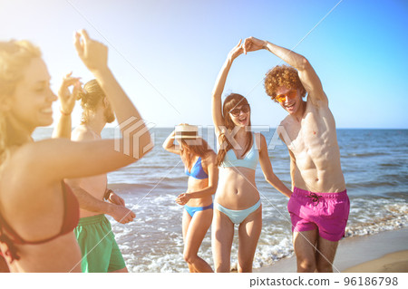 Group of friends dancing on the beach Group of friends dancing on the beach 96186798
