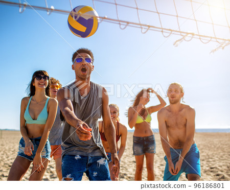 Group of friends playing at beach volley at the beach Group of friends playing at beach volley at the beach 96186801