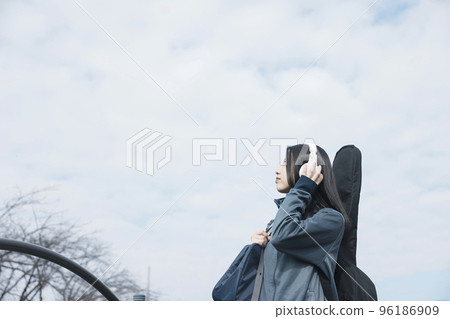 A high school girl who wears a jersey and goes to school with a guitar 96186909