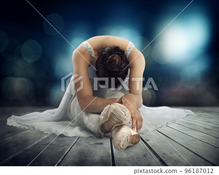 Classical dancer stretching on a stage of theater 96187012