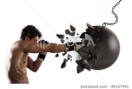 Power and determination of a young muscular boxer against a wrecking ball 96187941