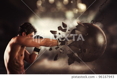 Power and determination of a young muscular boxer against a wrecking ball Power and determination of a young muscular boxer against a wrecking ball 96187943