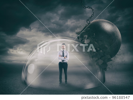 Businessman safely inside a shield dome during a storm that protects him from a wrecking ball. Protection and safety concept Businessman safely inside a shield dome during a storm that protects him from a wrecking ball. Protection and safety concept 96188547