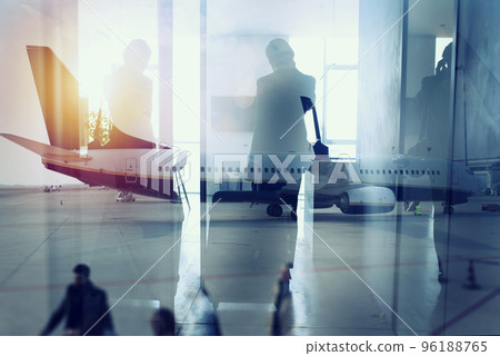 Silhouettes of businessman at the airport who waits for boarding. Double exposure Silhouettes of businessman at the airport who waits for boarding. Double exposure 96188765